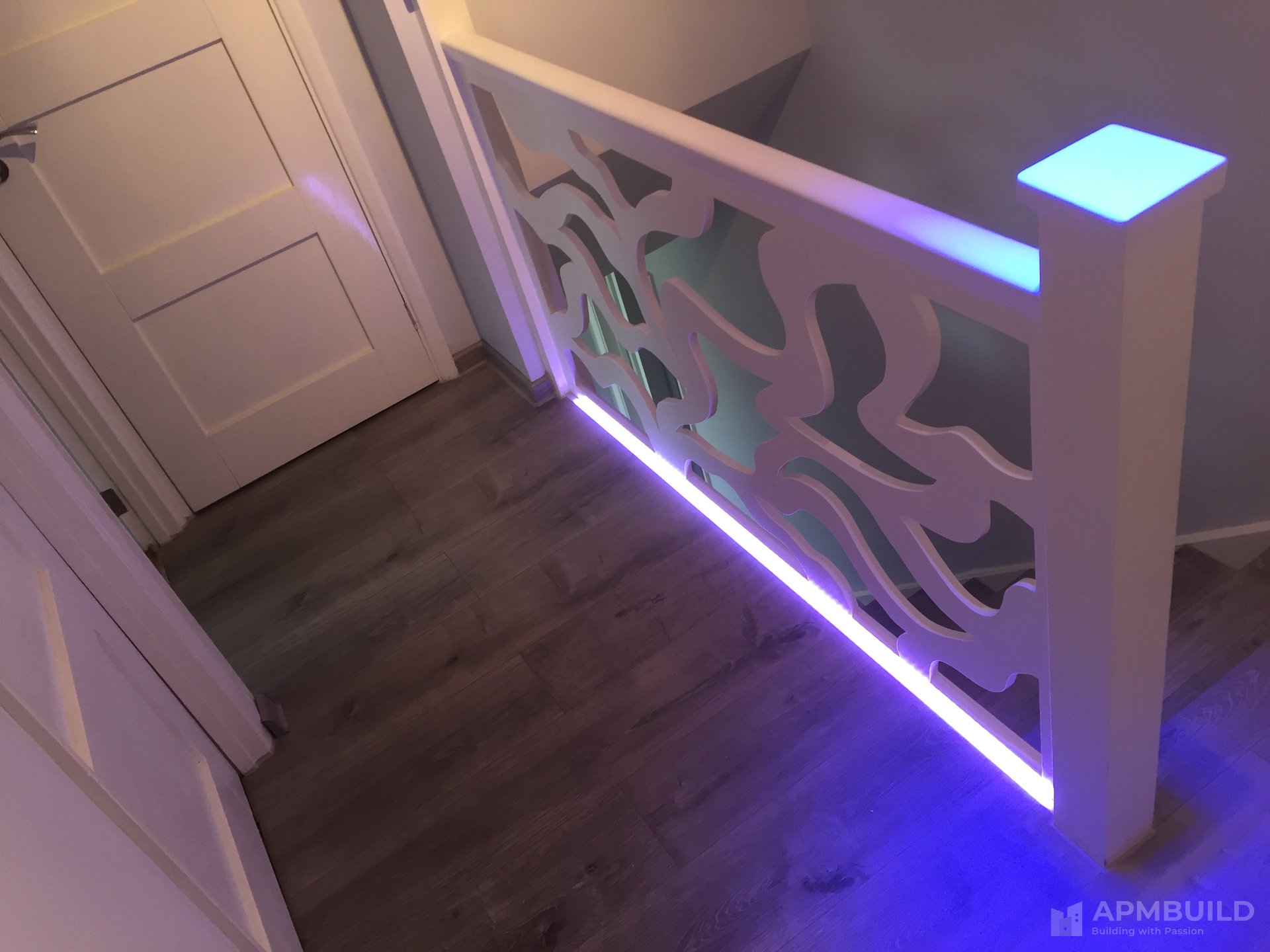 Bespoke hand-carved fretwork balustrade with concealed LED uplight in Herefordshire by APMBuild