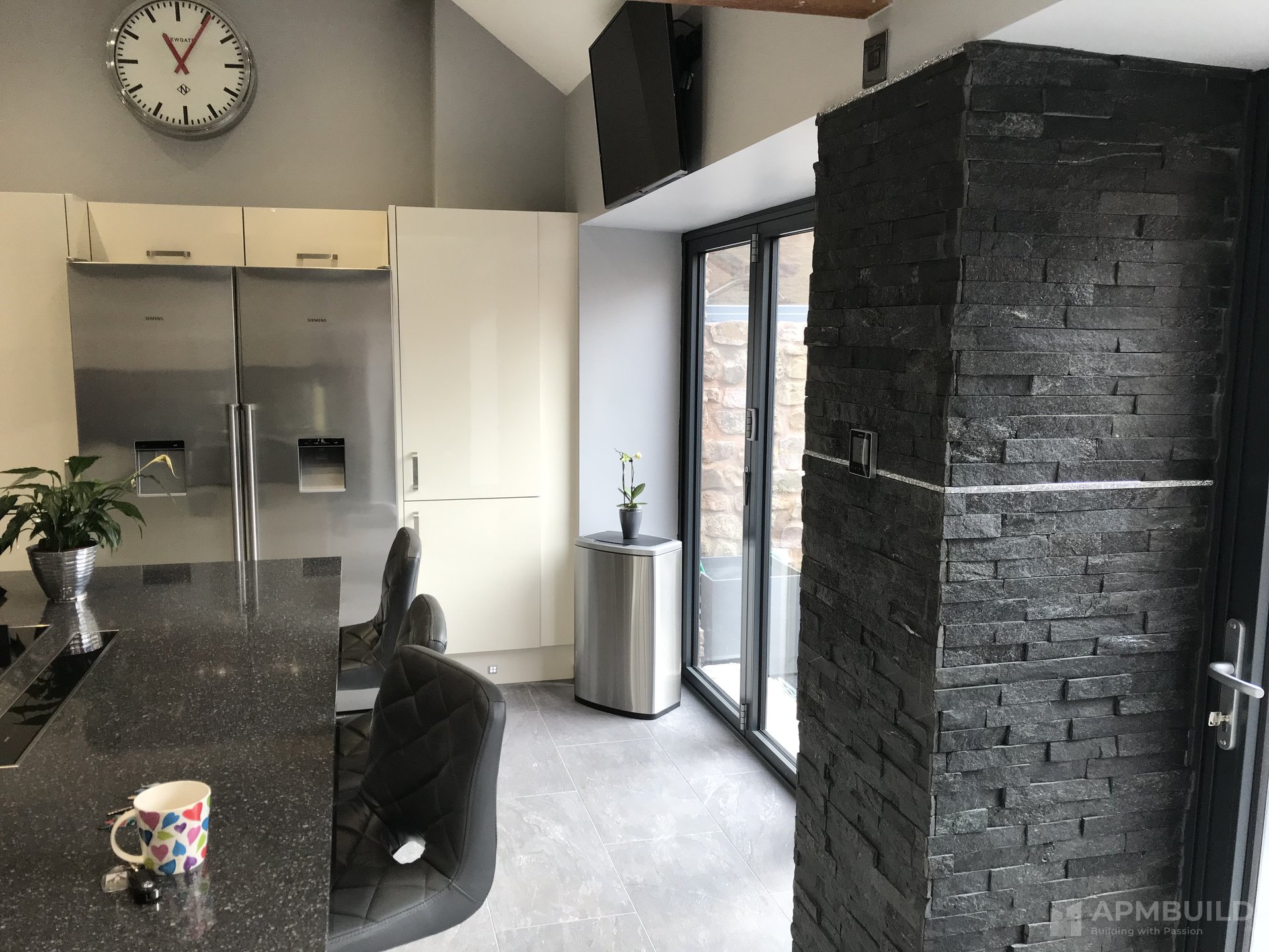 Completed kitchen with split-stone feature column and granite worktop in Lea Ross-on-Wye by APMBuild, Herefordshire