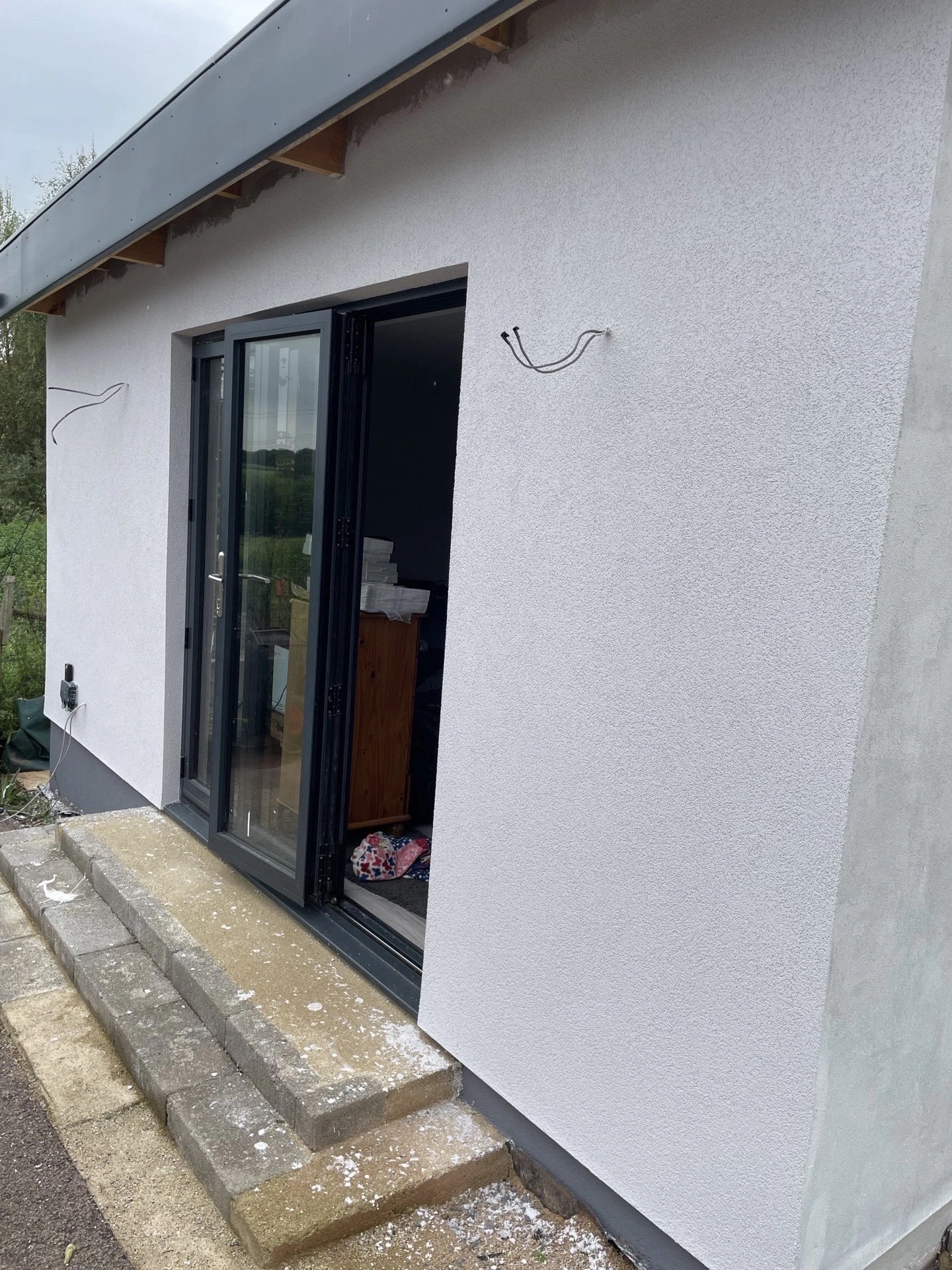 Completed garden gym building in Newent — silicone render and aluminium bi-fold doors, by APMBuild