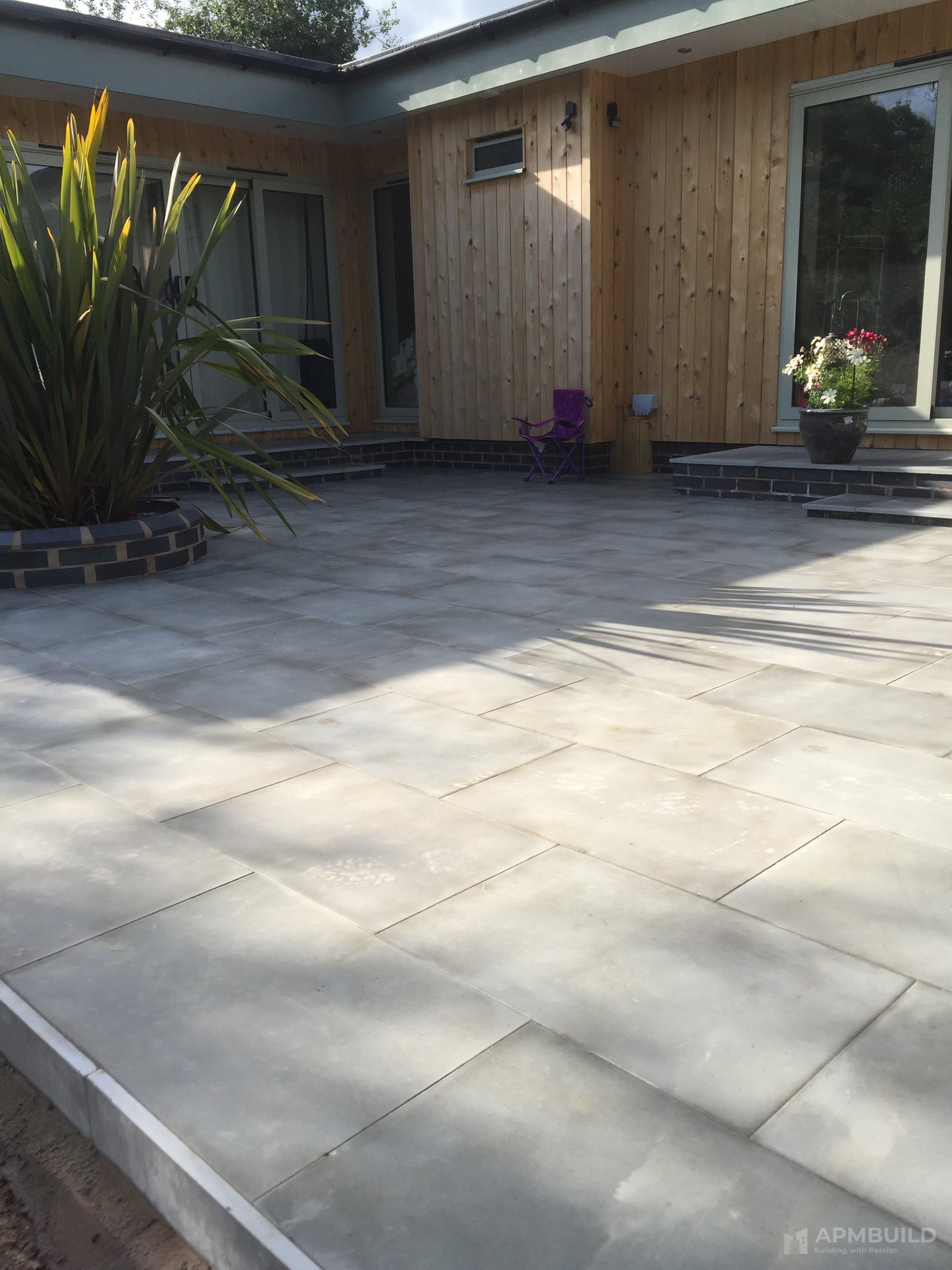 Completed patio meeting the house threshold with low brick step in Putley by APMBuild, Herefordshire