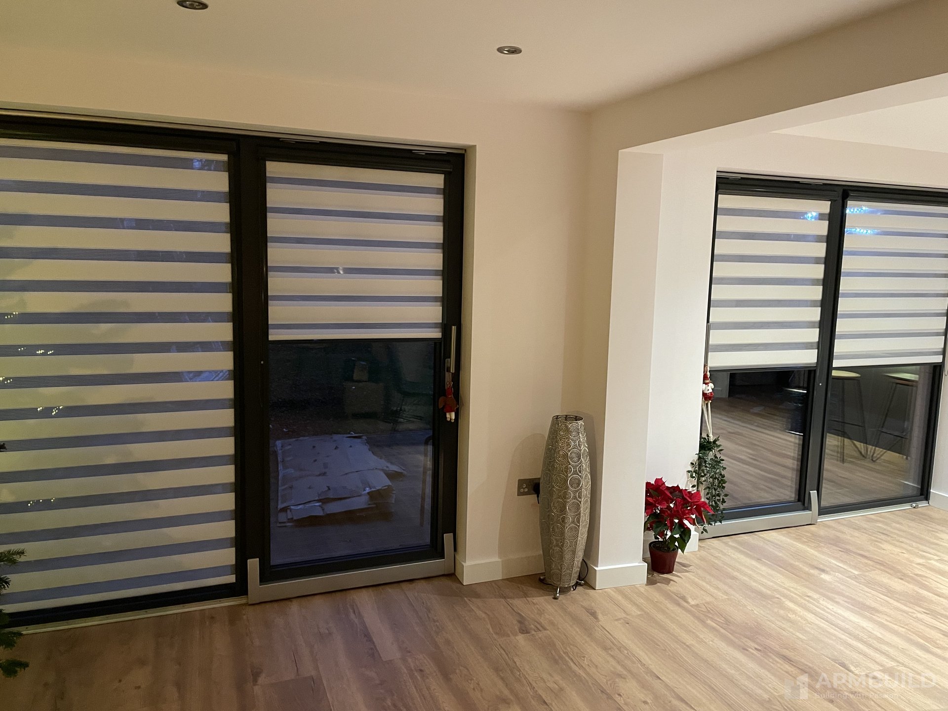 Completed hallway with full-height mirrored sliding storage and oak floor in Saxon Gate Hereford by APMBuild